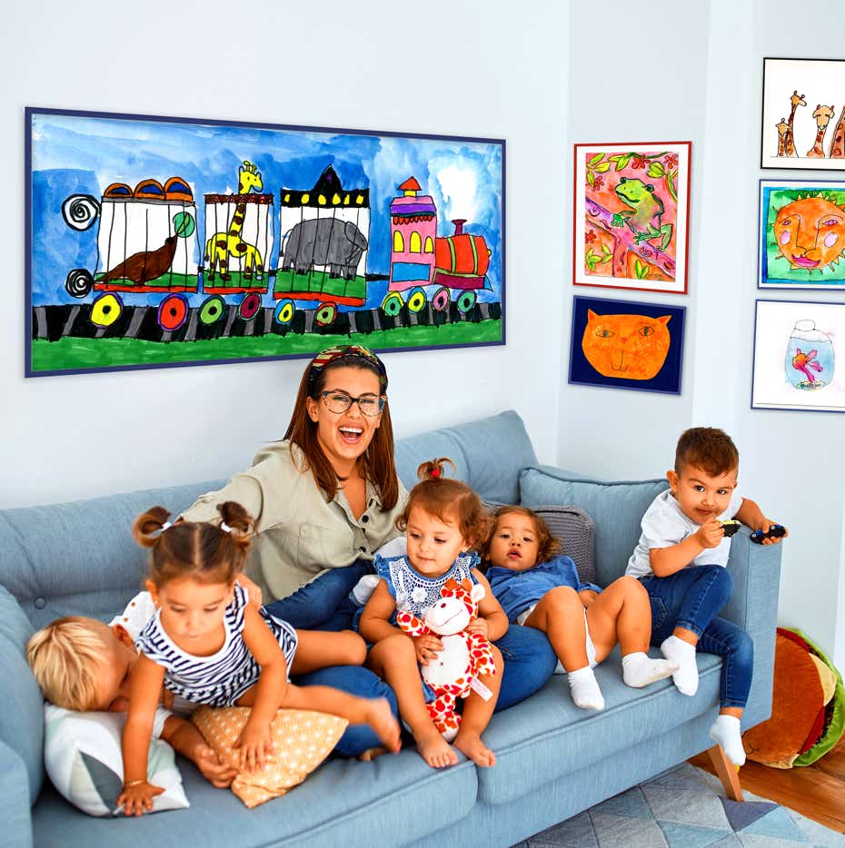 Family in Doctors office with wall prints featuring original art created by children. Circus Train, Froggy, Cat, Girraffe, sun, Gold fish